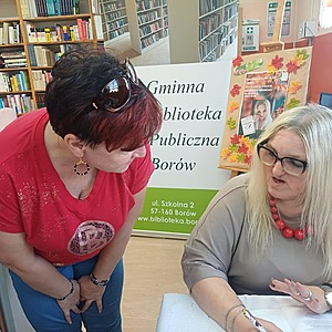 autorka podpisuje książkę a obok stoi kobieta