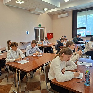 uczniowie siedzą w ławkach i piszą dyktando