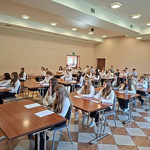 uczniowie siedzą w ławkach i piszą dyktando