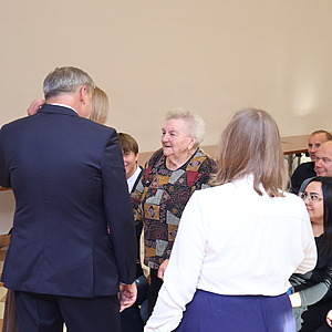 mężczyzna i dwie kobiety wręczają nagrodę kobiecie