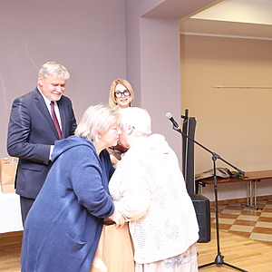 mężczyzna i dwie kobiety wręczają nagrodę kobiecie