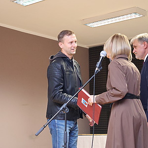 mężczyzna i kobieta wręczają nagrodę mężczyźnie